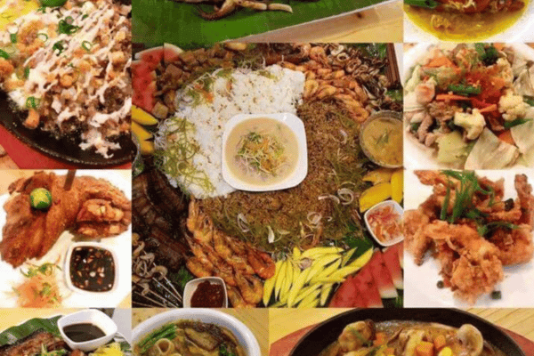 various filipino dishes, white rice, glass noodles in soy sauce, grilled shrimps, rice cake, pork crackling, and some vegetables