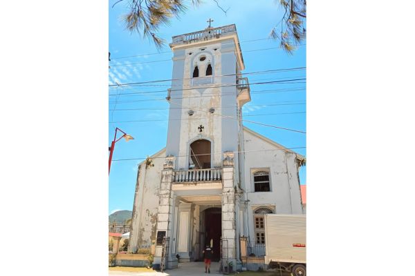 3 story white church with people going inside