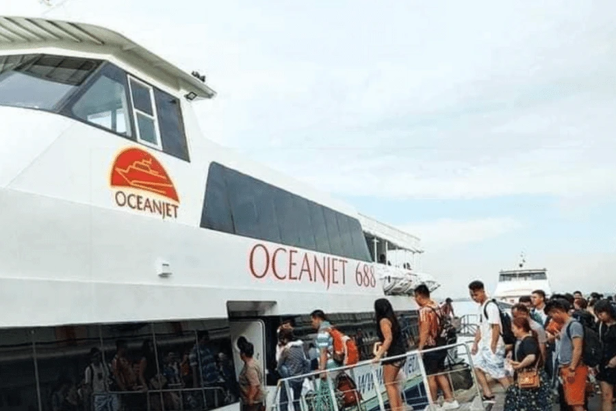a boat with the name oceanjet and some people lining up to get in to the boat