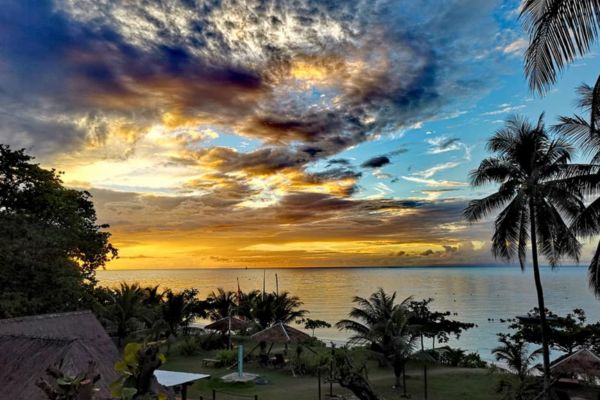 aerial view of a beach resort and the sky with a blue and orange color in the sunset
