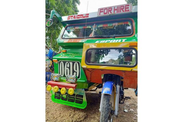 a tricycle with a green and red body and the body number 0619 and a label that says "for hire" at the top
