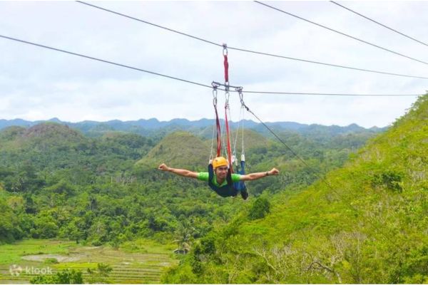 a male with arms wide open doing zipline with the expansive view of the surrounding