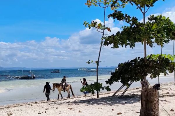 a horse-riding kid with a guide on moadto strip