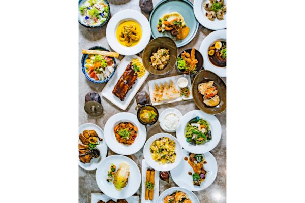 different local cuisines like pork barbecue,beef in peanut sauce,fish in coconut sauce, local fruits and vegetables all placed on a table like in a feast