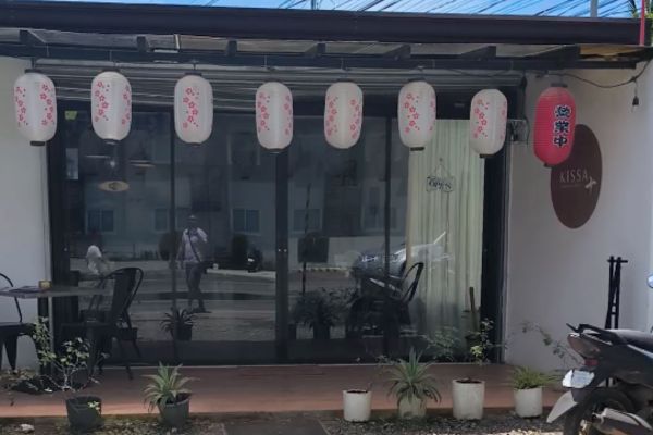 kissa japanese store front with a reflective glass and some paper lanterns
