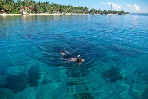 a man snorkeling in the clear blue water