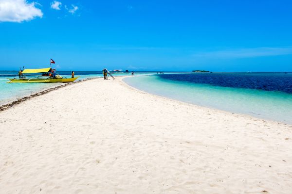 beach sand bar with white sand stretching as far as the eye can see meeting with the ocean