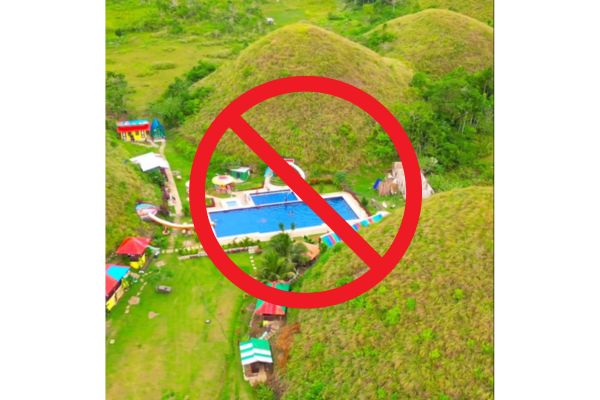 captain's peak and garden resort in the middle of chocolate hills with red prohibition sign